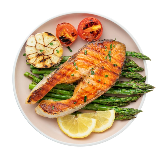 Plate of grilled trout steak and asparagus with ingredients isolated on white background Top view