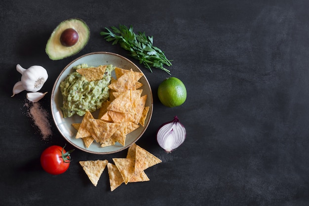 Plate of guacamole with tortilla chips and ingredients