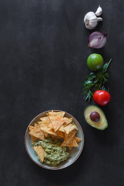 Plate of guacamole with tortilla chips and ingredients