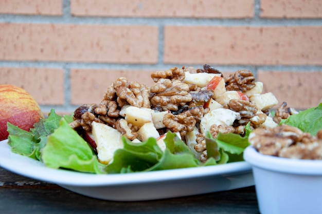 A plate of healthy Waldorf salad with applesraisins and walnuts