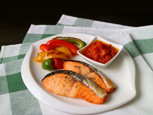 Plate of homemade grilled salmon steaks with colorful vegetables