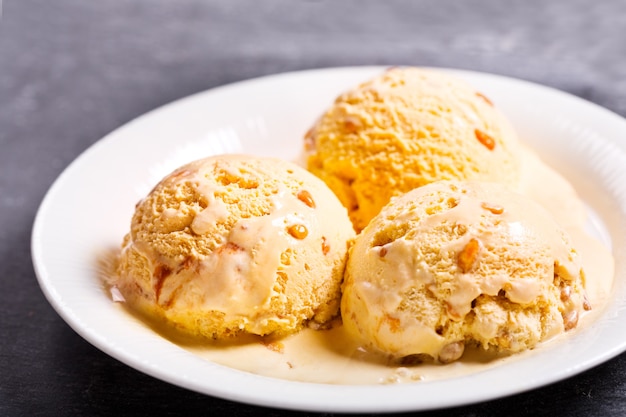 Plate of ice cream scoops on dark 