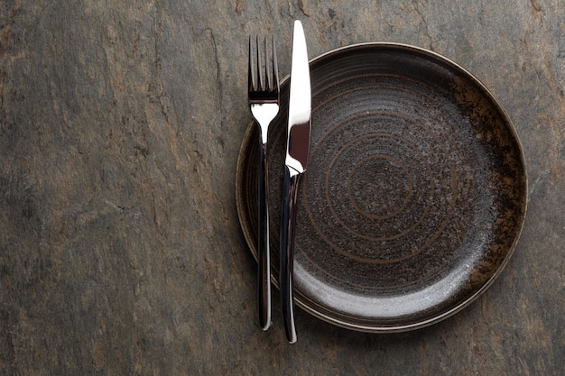 Plate knife and fork on stone background