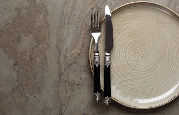 Plate knife and fork on stone background