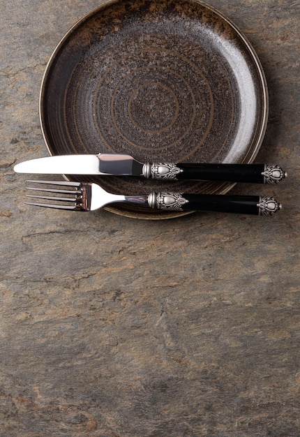 Plate knife and fork on stone background