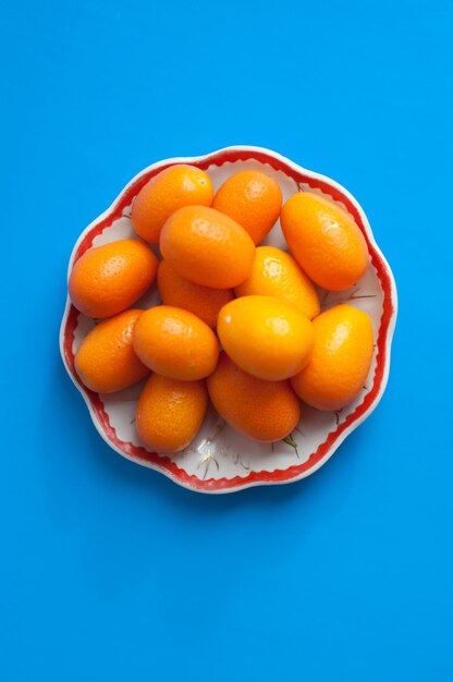 Plate kumquat on a colored background