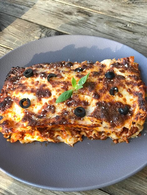 Foto un piatto di lasagne con sopra un'oliva nera