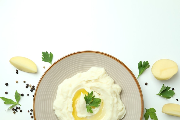 Plate of mashed potatoes and ingredients on white