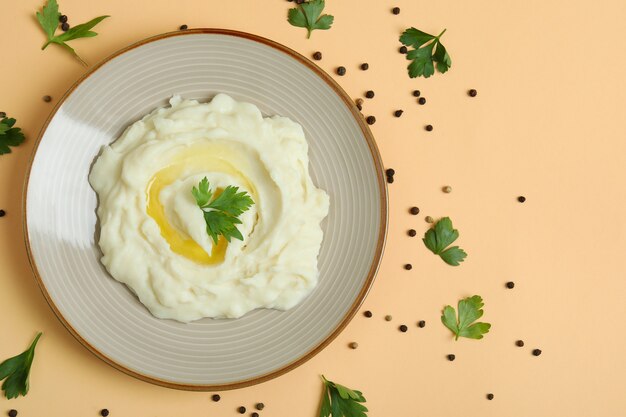 Plate of mashed potatoes and spices on beige background