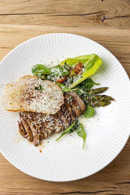 Foto un piatto di carne con un'insalata e un'insalata.