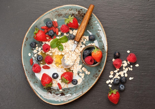 Photo plate of oatmeal fresh berries honey and milk a healthy breakfast top view