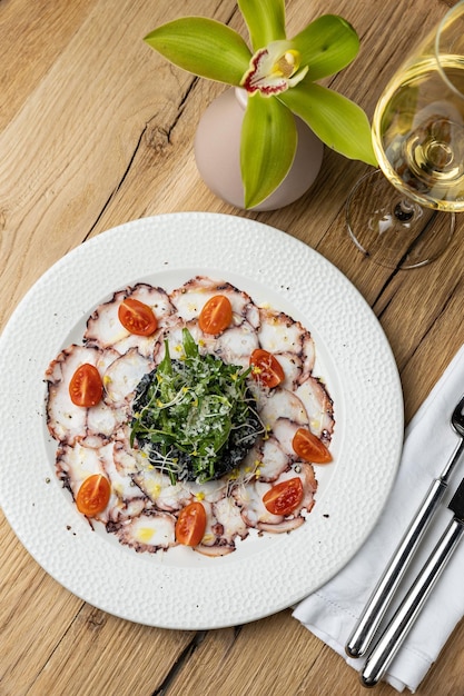 Photo a plate of octopus with spinach and tomato sauce