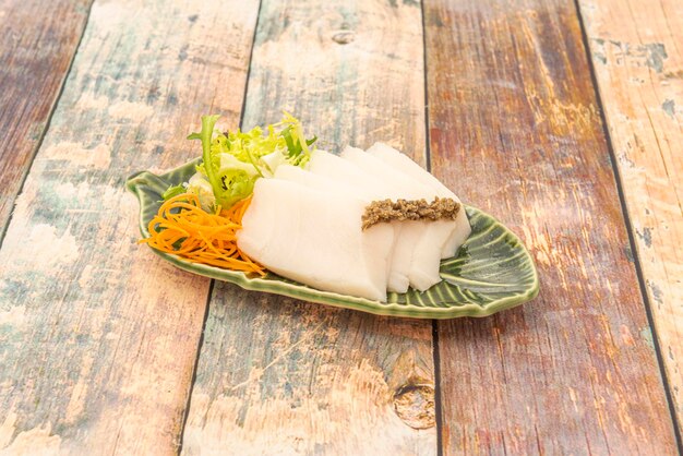 写真 小さな緑の葉の形をした皿にトリュフのバターフィッシュの刺身寿司のプレート