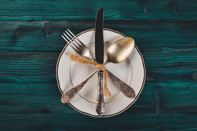 Plate and old cutlery On a wooden background Top view Free space for text