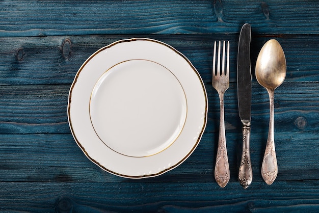 Photo plate and old cutlery on a wooden background top view free space for text