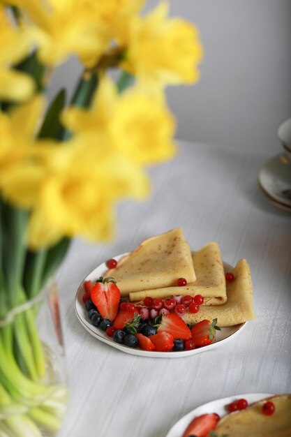 Foto un piatto di pancake con frutti di bosco e fragole sopra