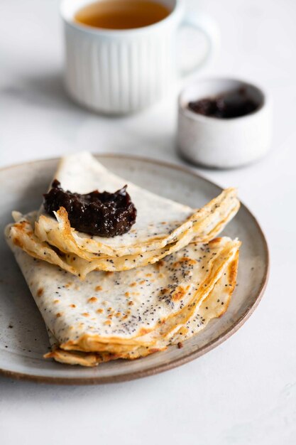 Photo a plate of pancakes with a jam on top.