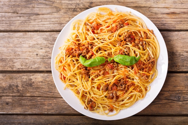 Plate of pasta bolognese on wooden table