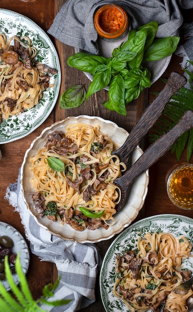 Plate of pasta with forest chanterelles and green basil