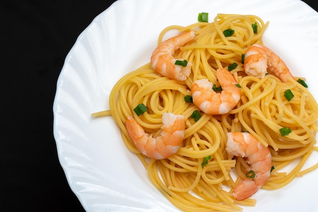 On a plate pasta with shrimp and herbs