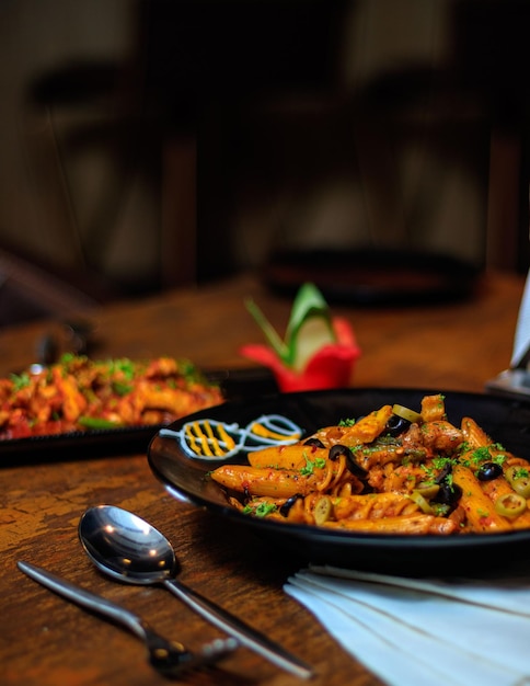 A plate of pasta with a spoon on the table