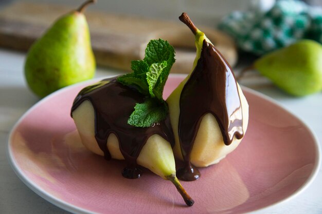 A plate of pears with chocolate sauce and a chocolate drizzle.