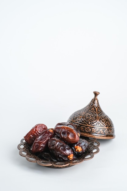 Plate of pitted dates isolated on a white background