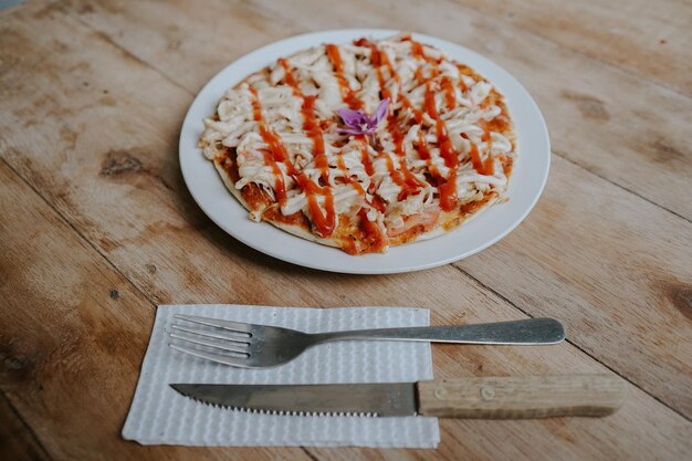 A plate of pizza with a fork and knife next to it