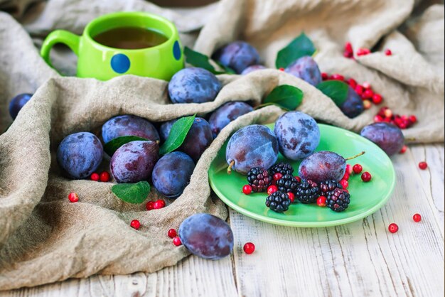 A plate of plums and a cup of maple syrup