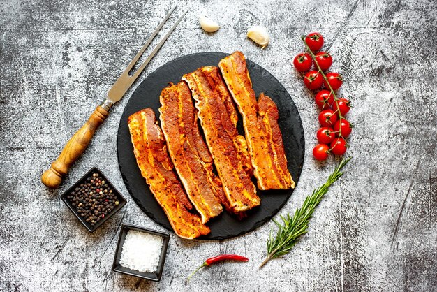 Photo a plate of pork ribs with a knife next to it.