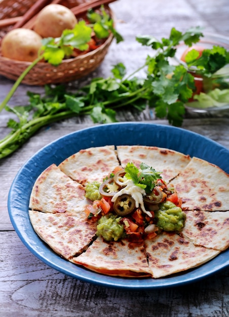 Photo a plate of quesadilla served with salsa, guacamole and jalapenos