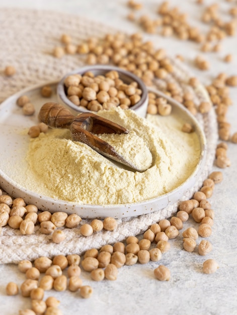 Plate of raw chickpea flour and beans on white table close up