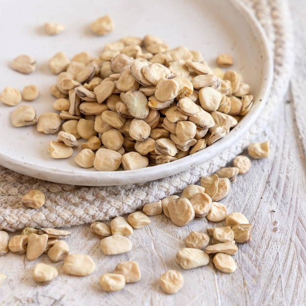 Plate of raw dry Grass pea close up on wooden table Legumes known in Italy as Cicerchia