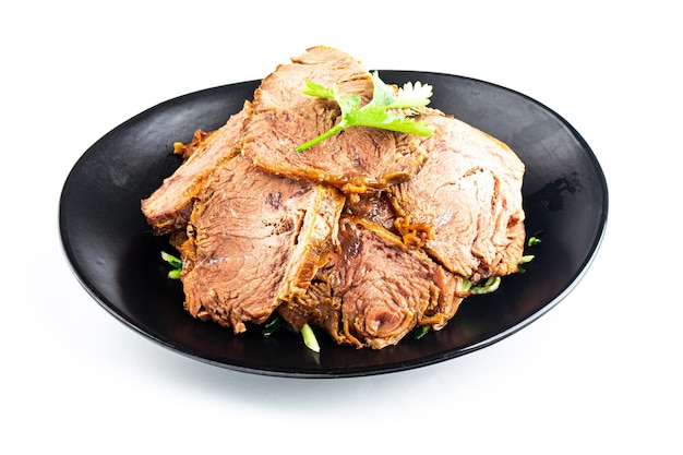 A plate of roast beef with green onions and green onions.