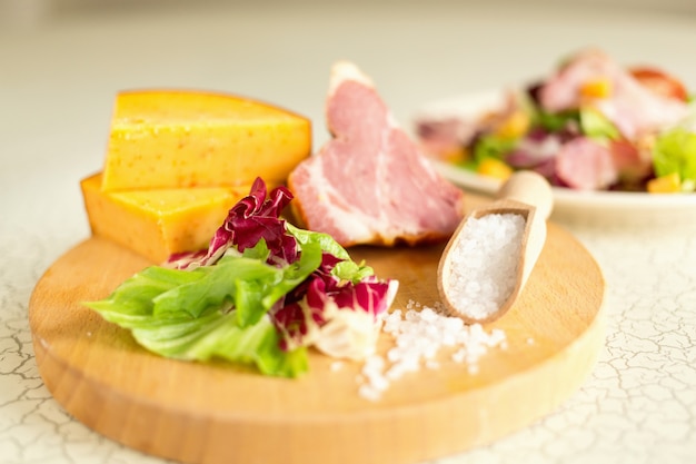 Plate of salad of green leaves, ham and cheese