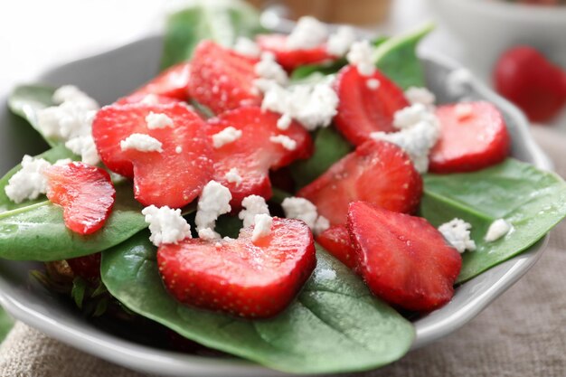 Plate of salad with spinach strawberry and cottage cheese on table closeup