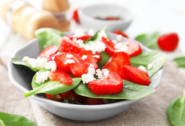 Plate of salad with spinach strawberry and cottage cheese on table