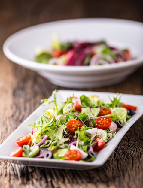 Plate of salad with vegetables  on rustic oak table Assortment of ingredients of vegetable salad