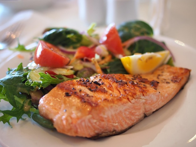 a plate of salmon salad and a salad with a slice of lemon