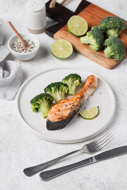 A plate of salmon with broccoli and lemon on the side.