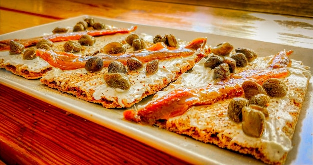 A plate of salmon with a red sauce and a white plate of food