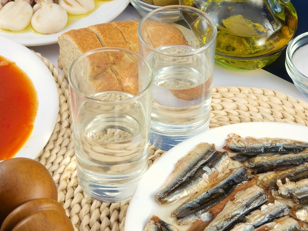 Foto un piatto di sardine è su un tavolo con pane e pane.