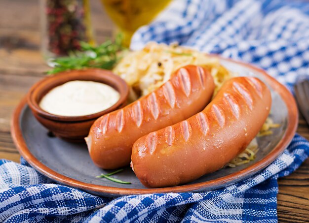 Piatto di salsicce e crauti sul tavolo di legno. menu tradizionale dell'oktoberfest