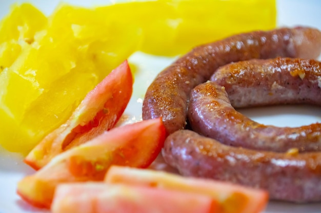 a plate of sausages and tomatoes with a yellow plastic bag