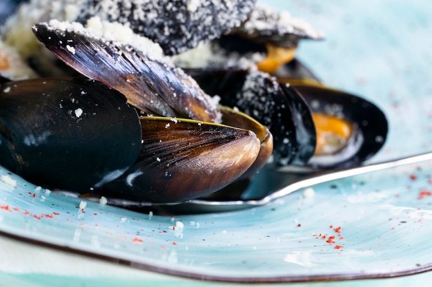 A plate of seafood mussels with cheese sauce