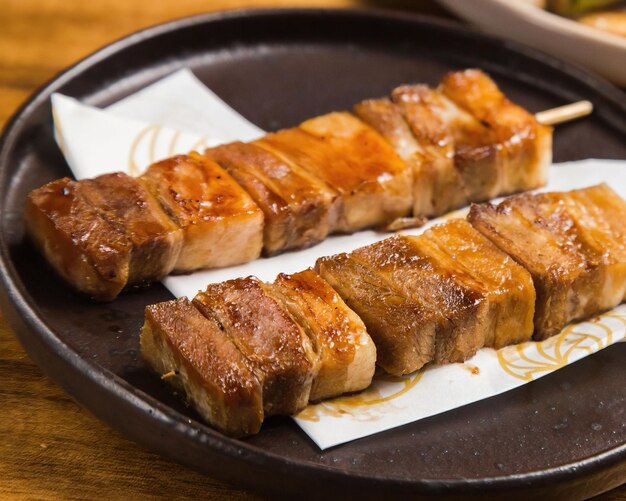 A plate of shiitake on a wooden table with a plate of food