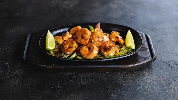 A plate of shrimp with lime wedges and a lime wedge