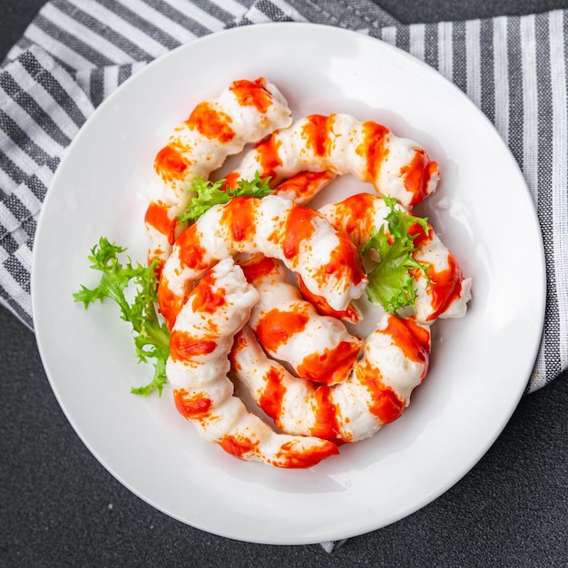 A plate of shrimp with a sprig of parsley on top