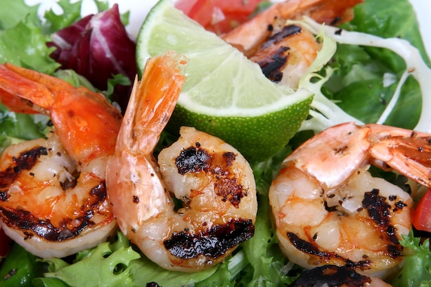 a plate of shrimps with a green leaf on top of it