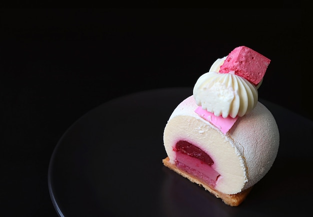 Plate of Slice of Strawberry Vanilla Mousse Cake with Copy Space on Black Background